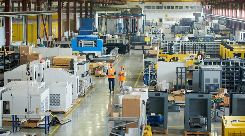 Image of two factory inspectors working around a large warehouse floor to support auto strike article