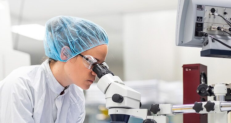 Scientist looking through microscope