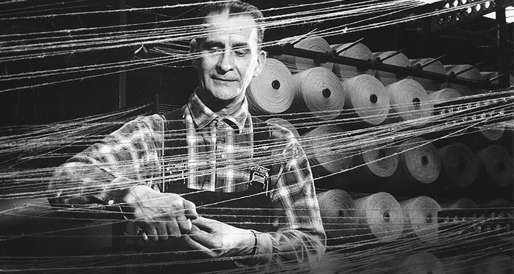 Black & white image of a man with many yarns weaving