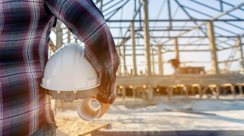 Digital image of a construction worker stood on a worksite with scaffolding to support manufacturing outlook article