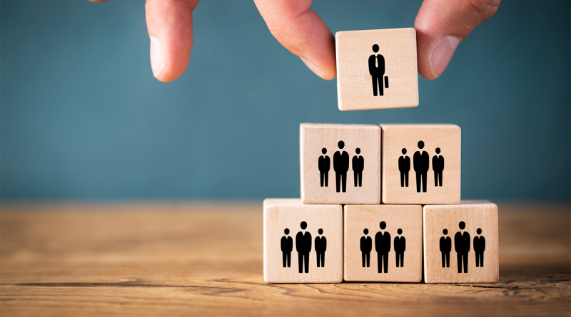 Image of some wooden blocks stacked on top of each other with different business member silhouettes on to support Aerotek article