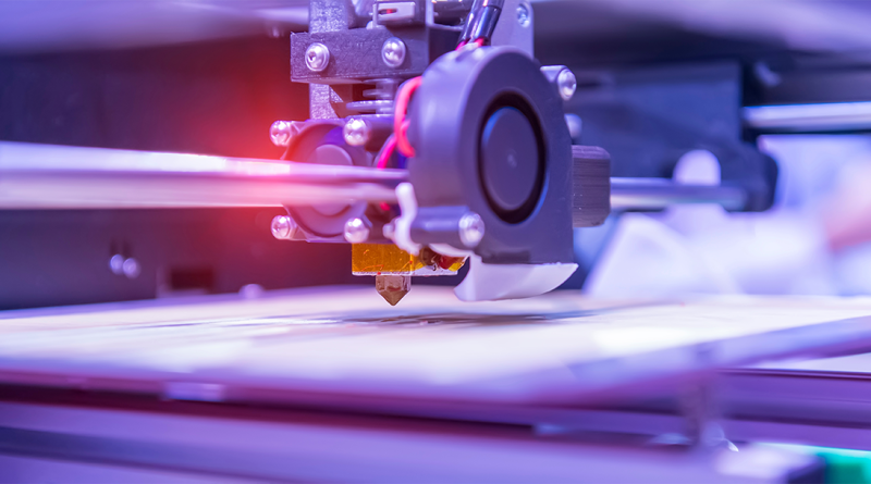 Close-up of a 3D printer working in a purple light to support Rapid + TCT 2024 article