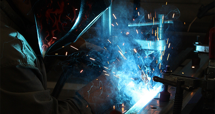 Close up of welder working, welding metal.