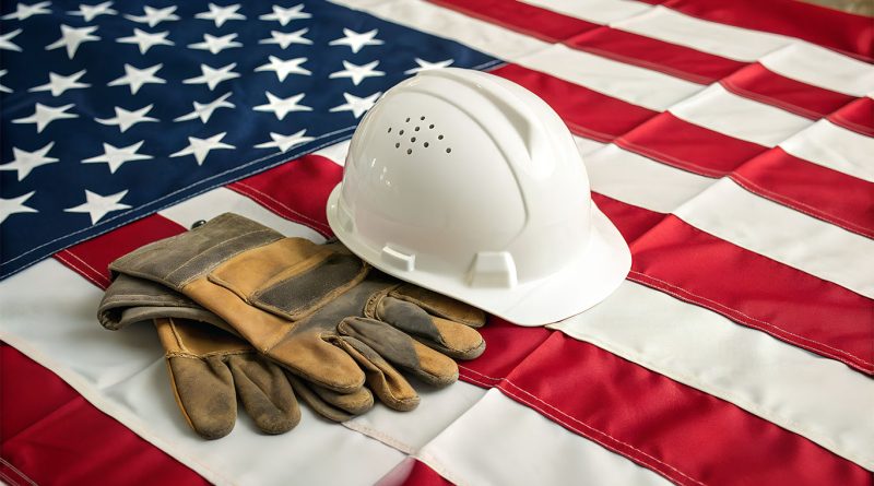 Hard hat and workers gloves laid on American flag to support Made in America article