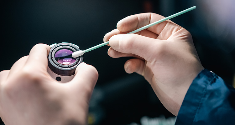 a person cleaning or maintaining a component of a laser system,