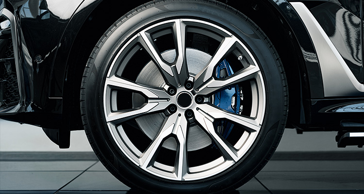 an alloy wheel with a two-tone finish and a visible blue brake caliper.