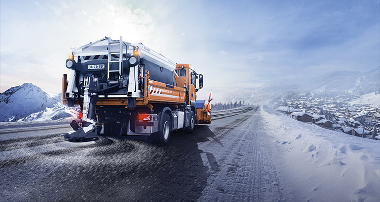 a Bucher Municipal snowplow and salt spreader truck clearing a snowy road