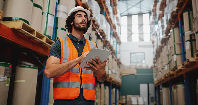 a warehouse worker using a tablet to manage inventory