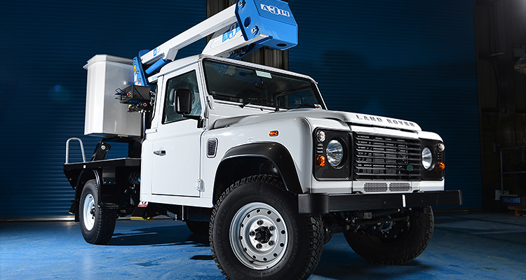 a Land Rover Defender 110 equipped with an aerial work platform or "cherry picker".