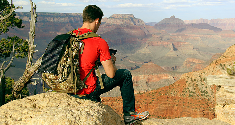 a person sitting on the South Rim of the Grand Canyon.