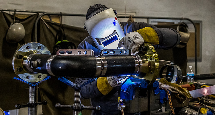 a welder performing pipe fabrication in a workshop