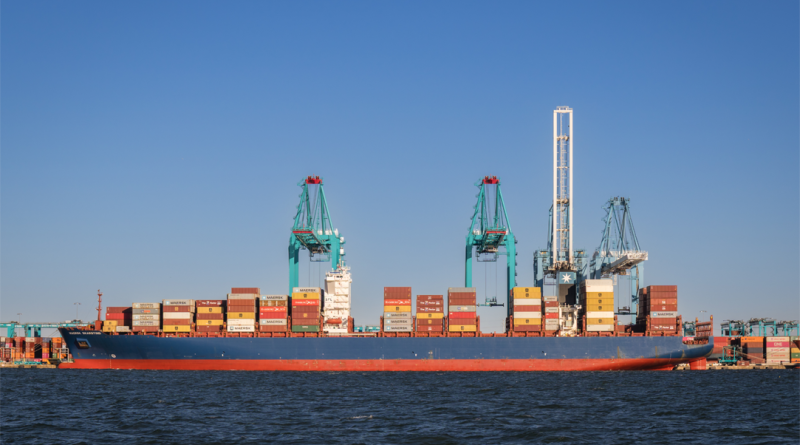 Large international cargo ships in harbor being loaded with shipping containers